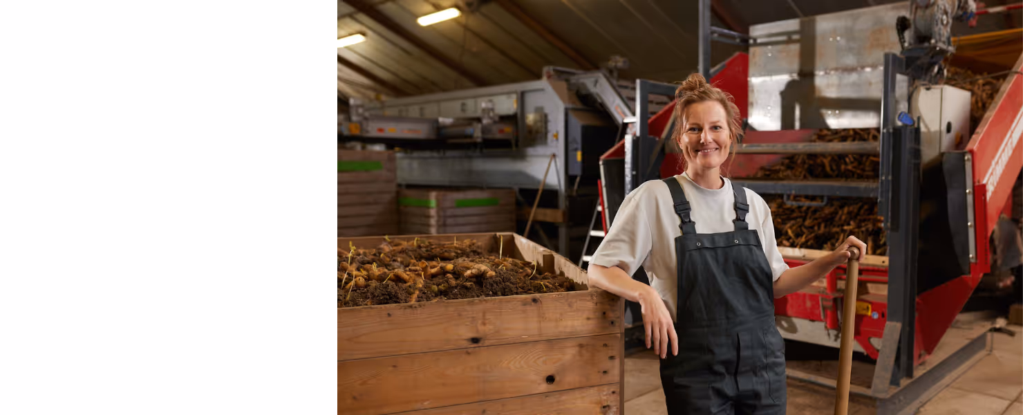 lachende boerin in loods met wortelen